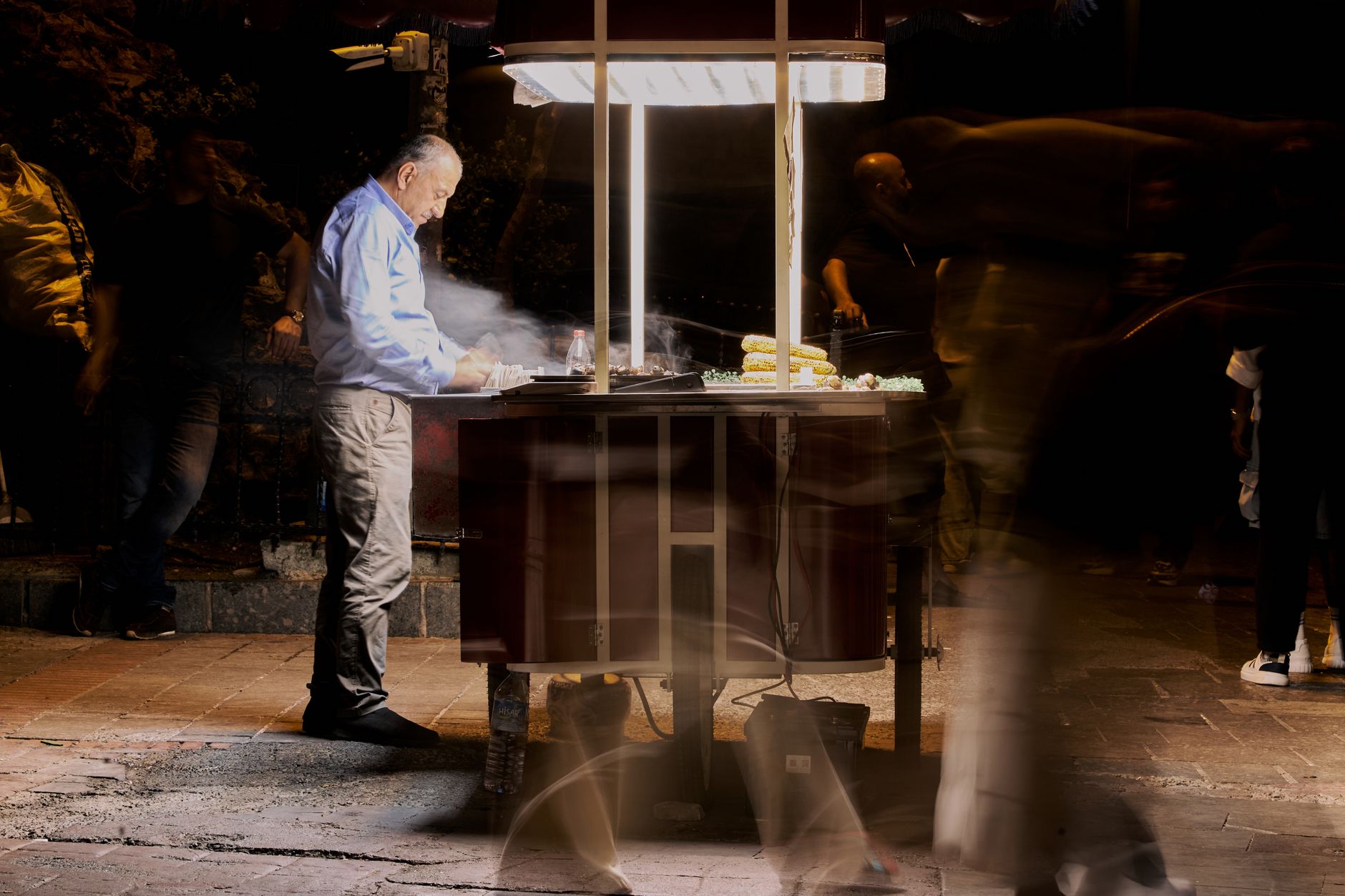 Street vendor cooking food at night with blurred people passing by. — Accurate Asbestos Test Results Available in 24 Hours