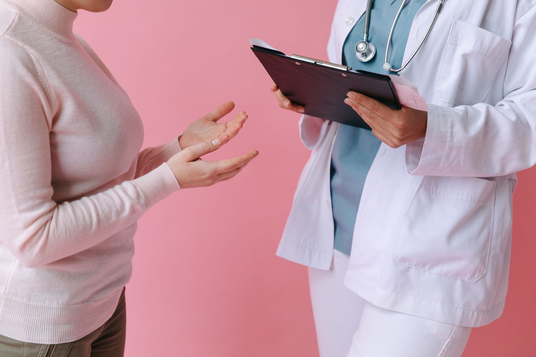 Close-up of a patient consulting a doctor with a clipboard in a medical setting. — Dr. Sagy Grinberg Delivering Compassionate
