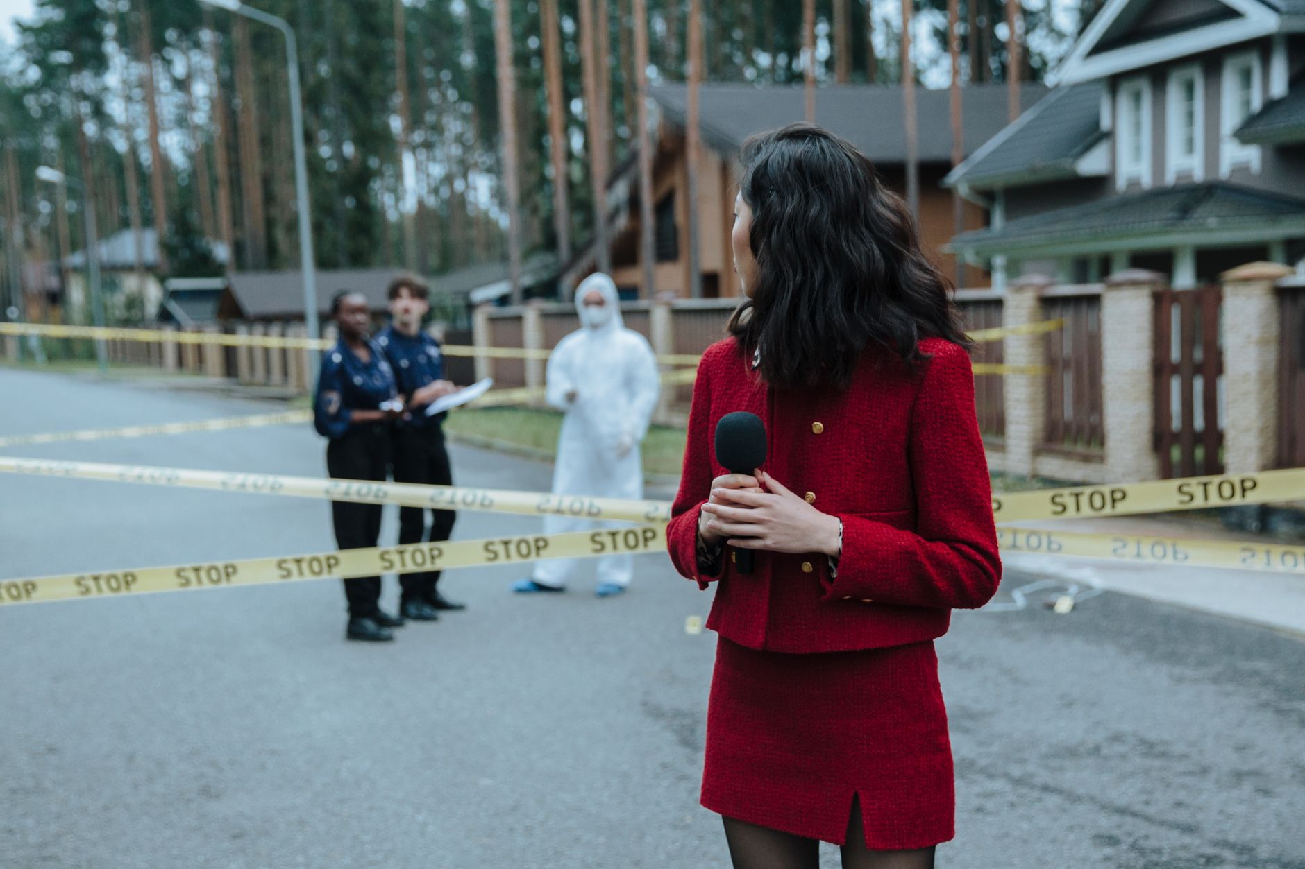 Reporter at a crime scene with police and forensic experts. Yellow caution tape visible. — Exploring Affordable Options for S