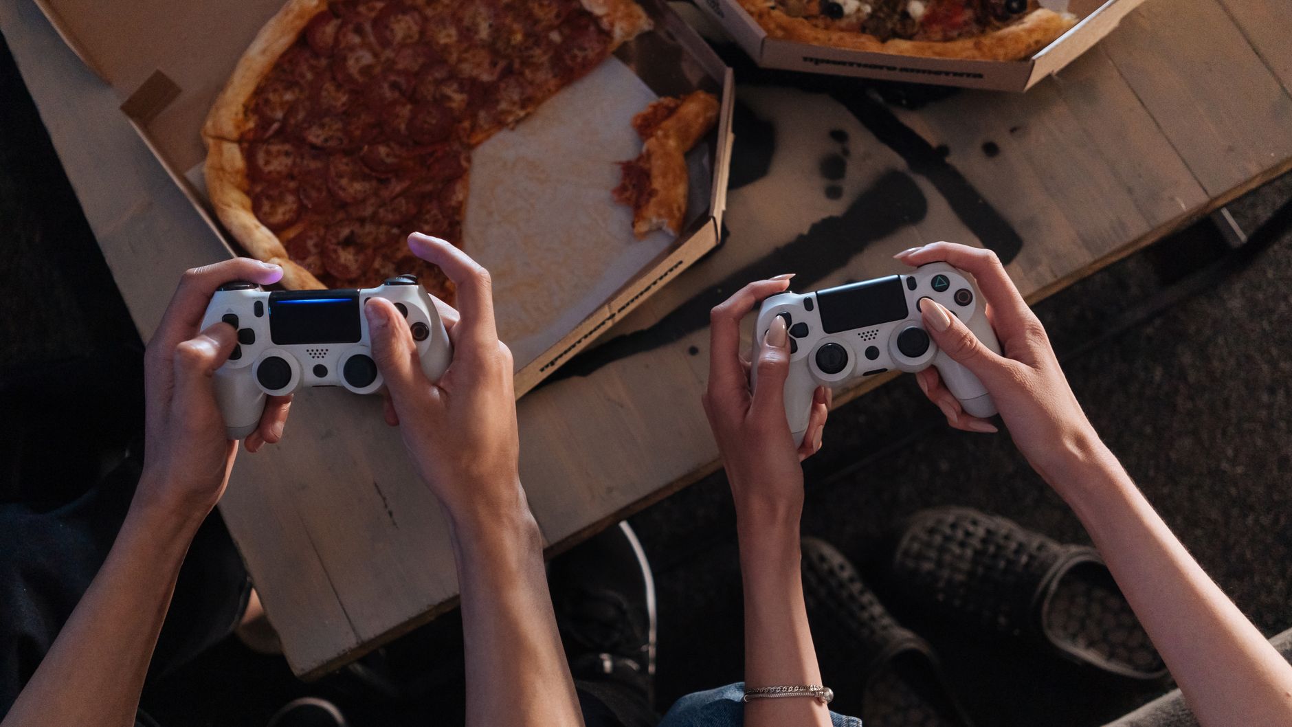 Two people enjoying a gaming session with pizza, creating a cozy and fun atmosphere. — Exploring the VIP Rewards and Promotio