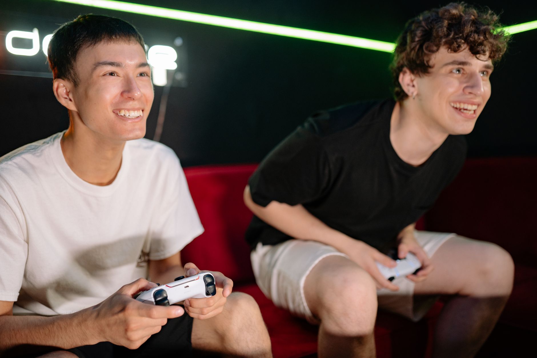 Two friends having fun playing video games indoors, captured in a lively and engaging moment. — Get Involved in Football Bett