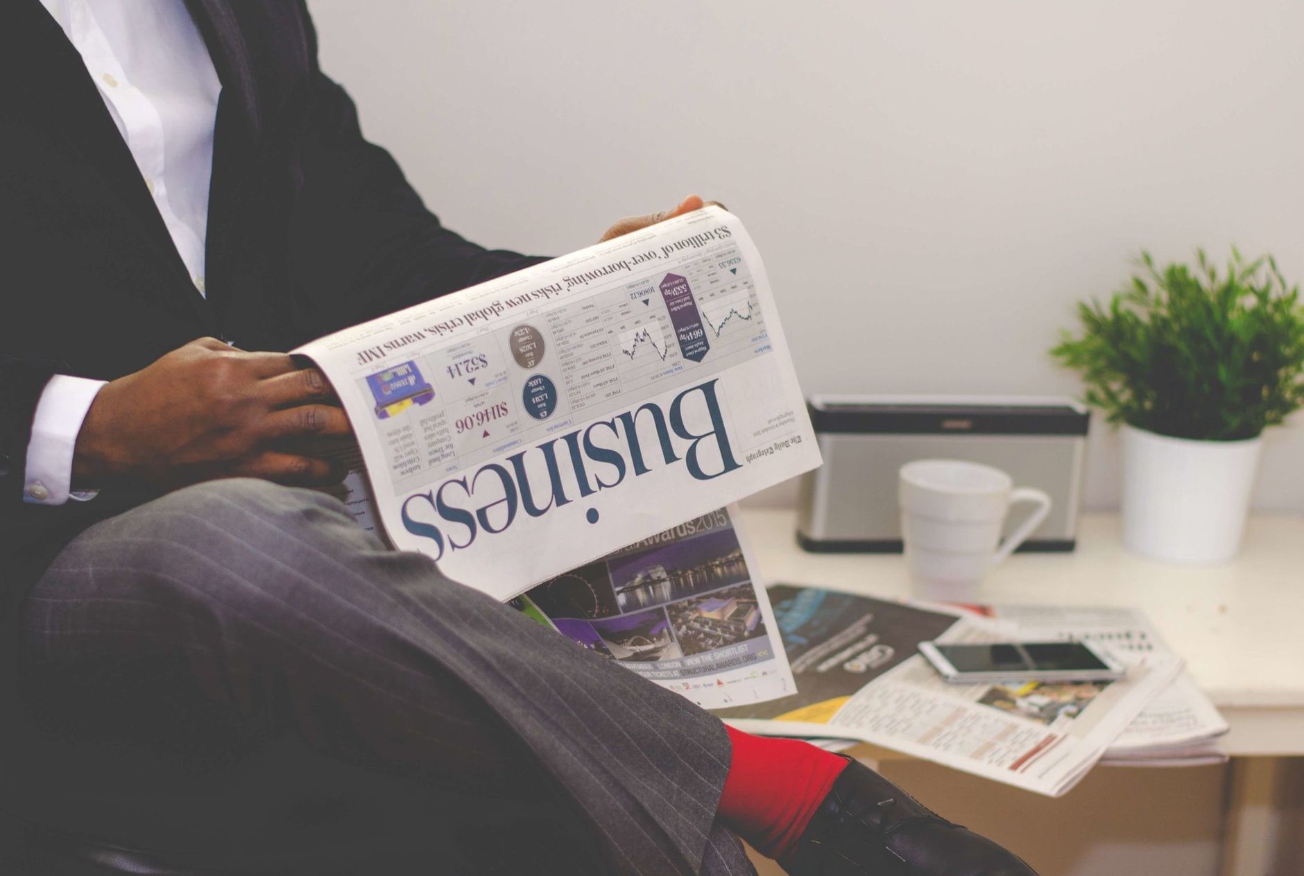 Businessman reading a financial newspaper at a desk, highlighting finance and commerce theme. — Innovating Patient Care: Dr.