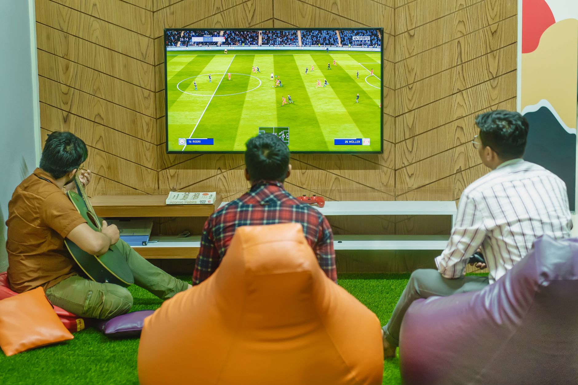 Three friends relaxing and playing a soccer video game indoors on a comfortable game night. — Mastering the Spin: A Guide to