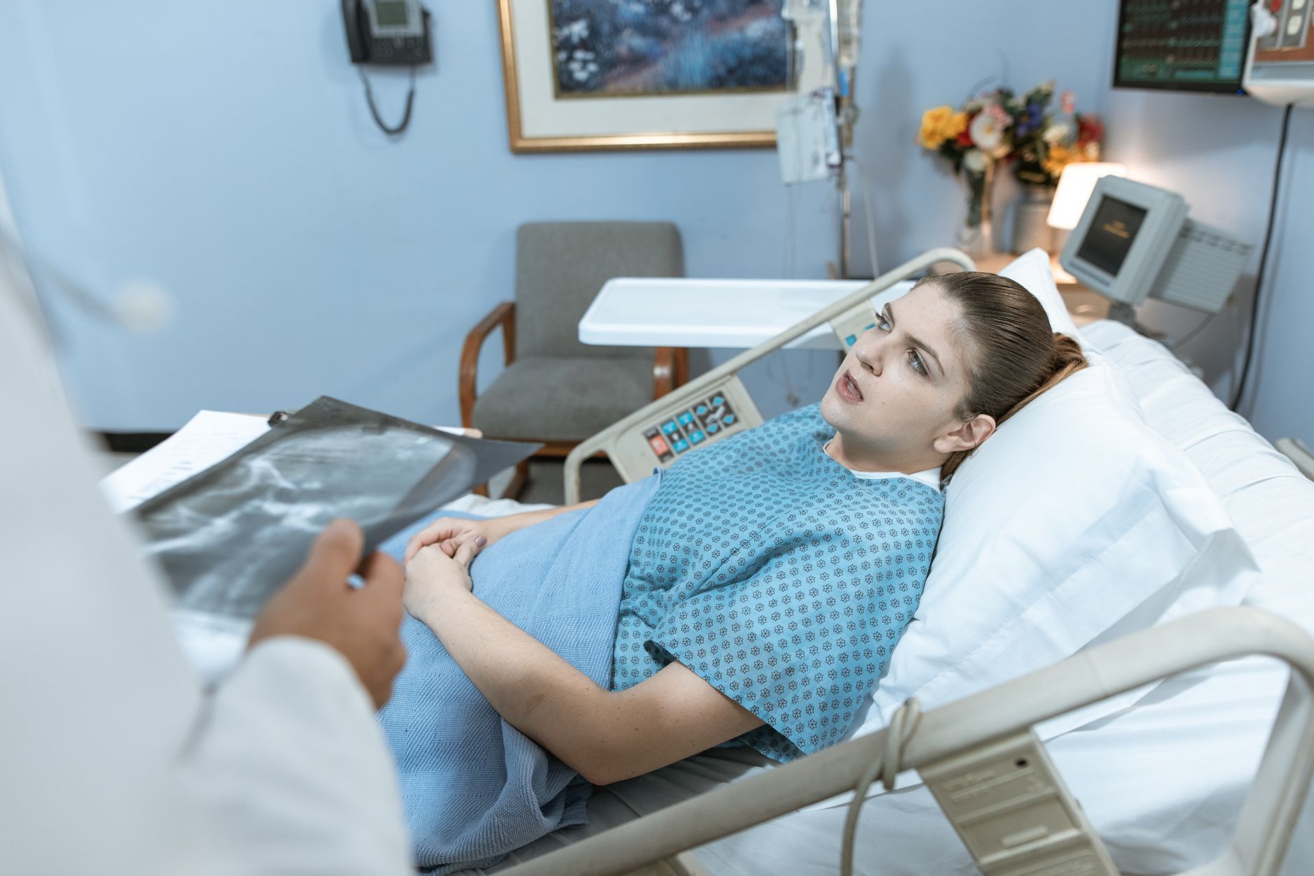 Caucasian woman in hospital bed receiving care from healthcare professional. — Next-Gen Emergency Solutions: How Dr. Robert C
