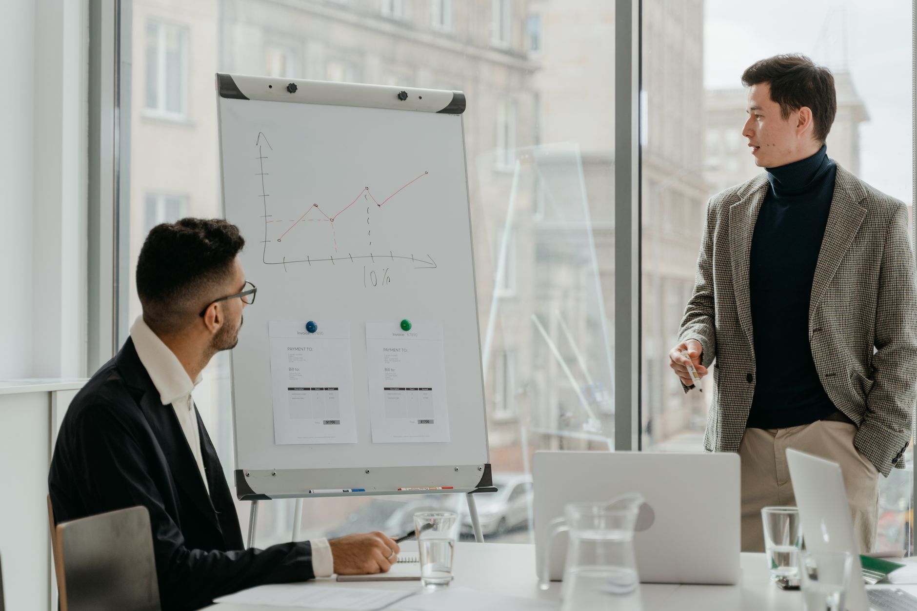 Professionals discussing a business chart in a modern office. — Nurturing Nature: Dr.Nepute's Visionary Impact on the Future