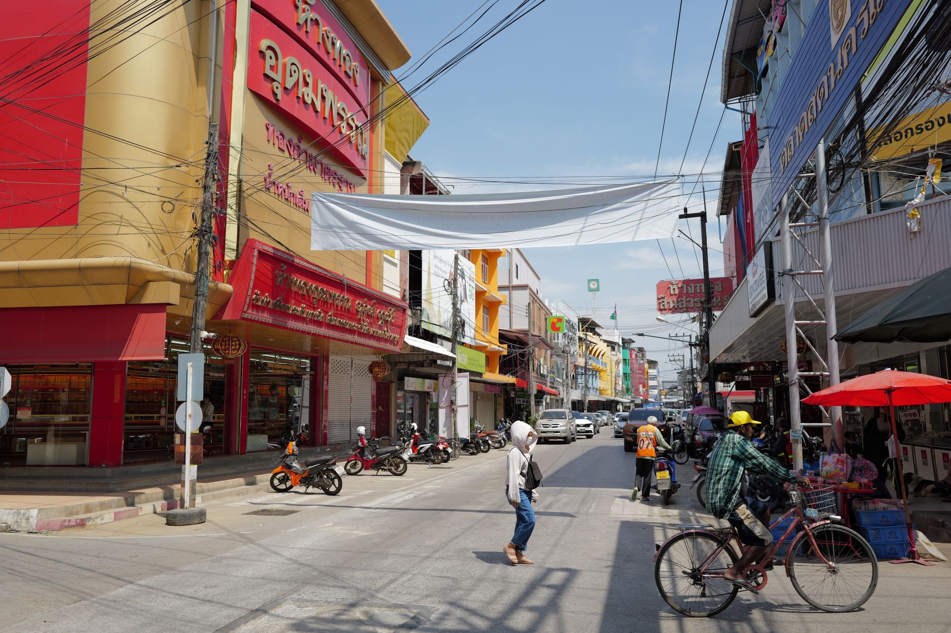 Lively urban street in Thailand with people, shops, and traffic under a sunny sky. — Own the Arena: Valorant High-Elo Account