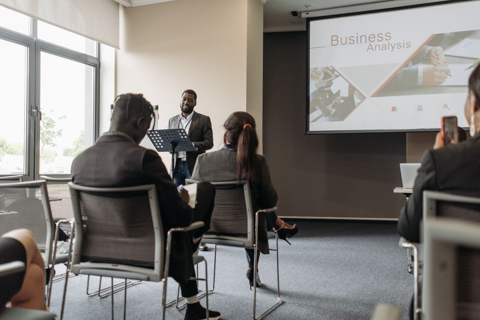 A business professional delivering a presentation in a conference room with diverse attendees. — Revolutionizing Care: Dr. St