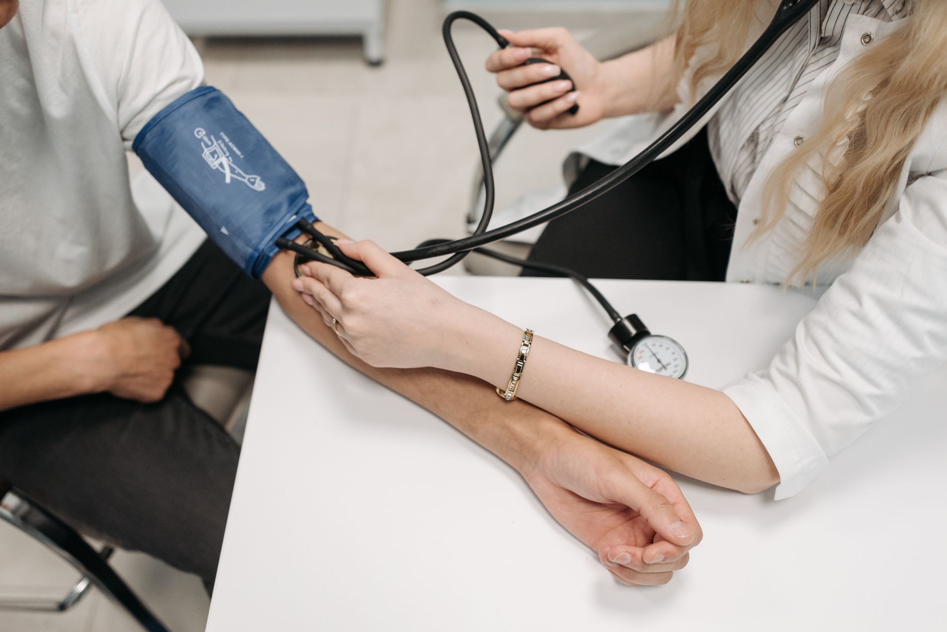 A doctor measures a patient's blood pressure with a sphygmomanometer during a consultation. — Secure Your Health with Medicar