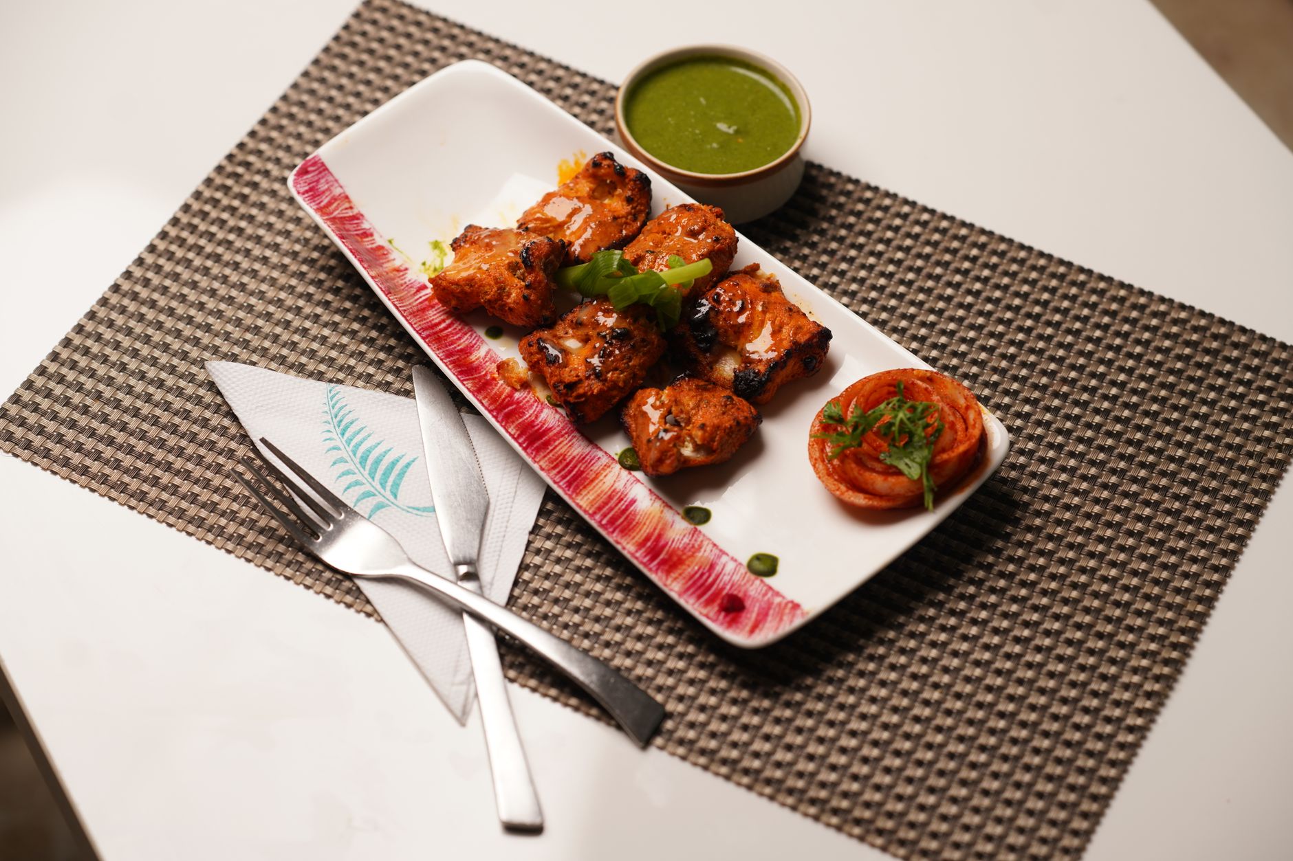 A delicious grilled chicken dish served with green sauce on a neatly set table. — Taste Adventure: The Unique Flavours of Jap